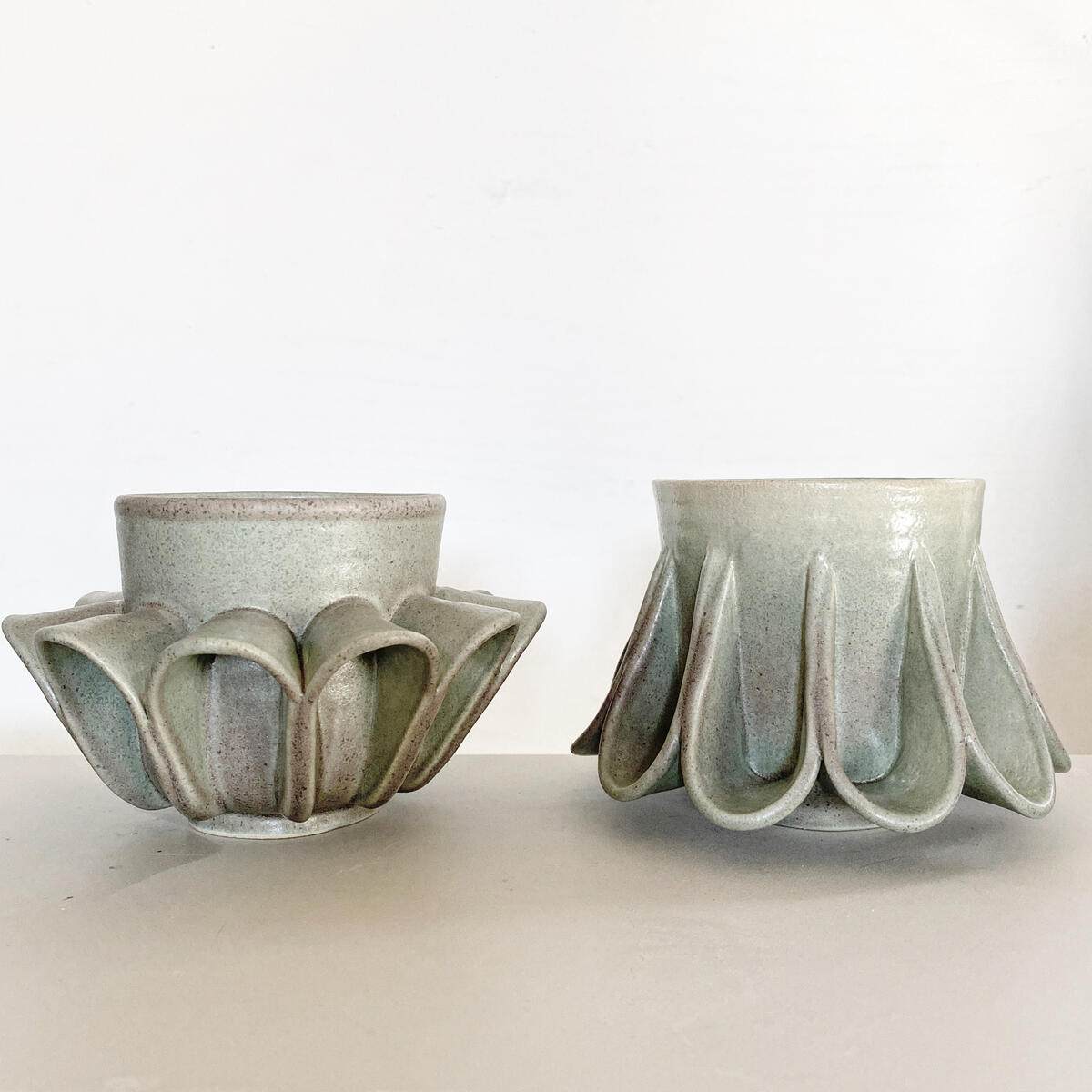 “Textile Drape” Ceramic Cups — sculptural designer pottery from Natty Ceramics atelier in Utrecht Two handcrafted ceramic cups with pleated base texture, glazed in soft mint tones — part of “Safe Mugs” series