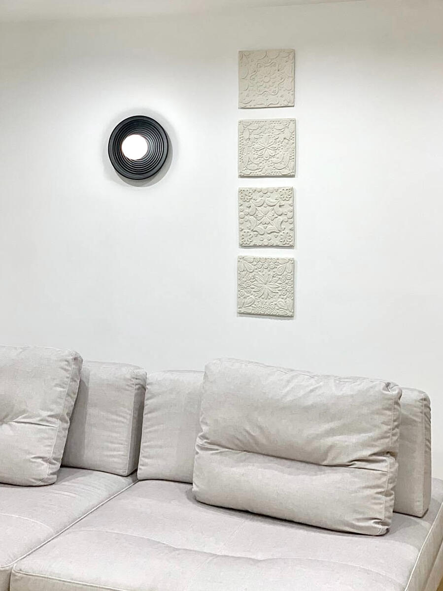 Relief ceramic wall panels — sculptural interior accents from Natty Ceramics atelier in Utrecht Vertical arrangement of handcrafted ceramic relief wall panels on a light wall in a bright modern interior